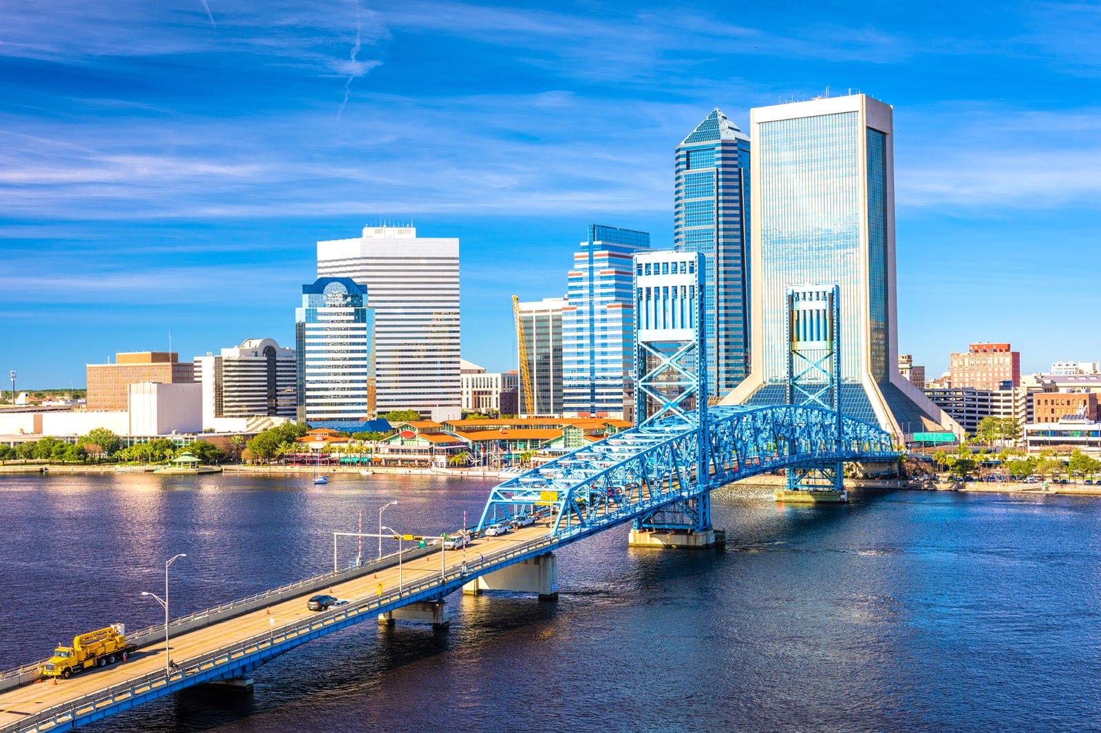 A bridge over the water with buildings in the background.