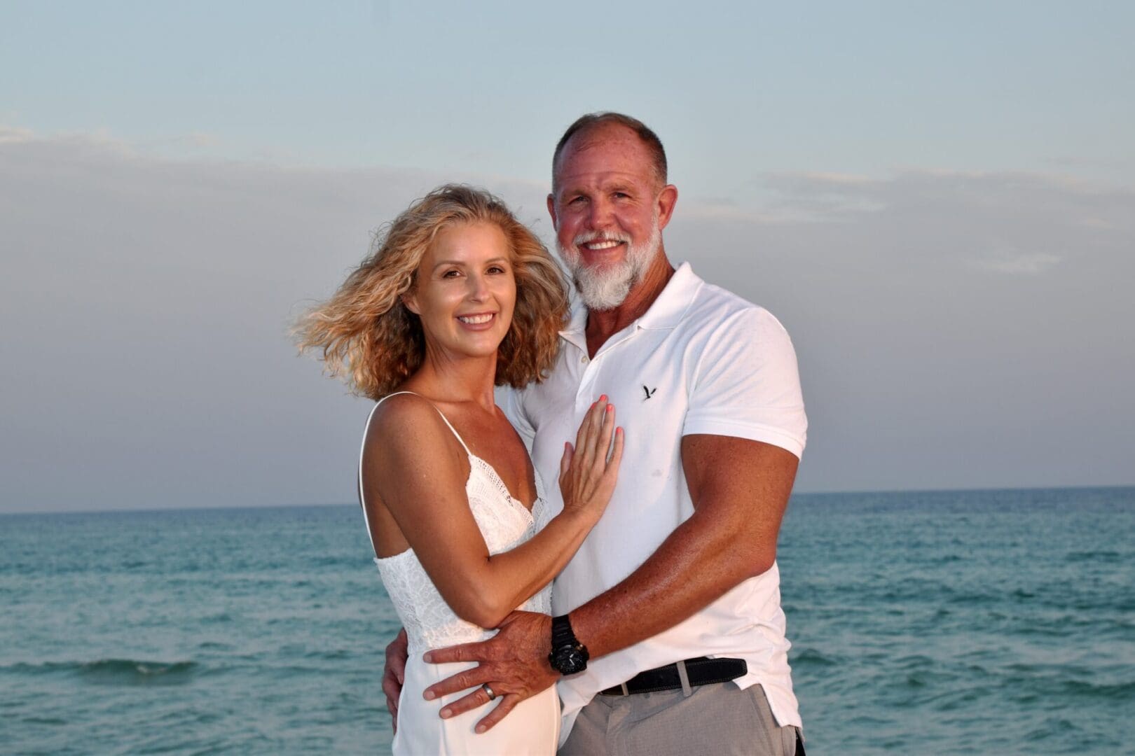 Smiling couple embracing by the ocean